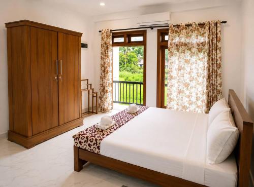 a bedroom with a large bed and a window at Nine Gems villa in Kandy