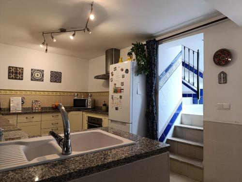 a kitchen with a sink and a refrigerator at Casa Cal y Sol in Olvera