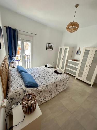 a bedroom with a bed with blue pillows on it at Casa Cal y Sol in Olvera