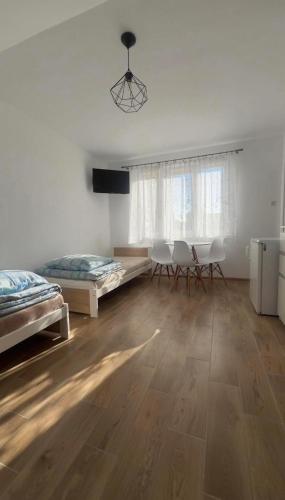 a room with two beds and two chairs and a table at Kapitańska Przystań in Chłopy