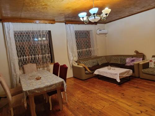 a living room with a couch and a table at Kirayeev Hamarmeşə in Lerik