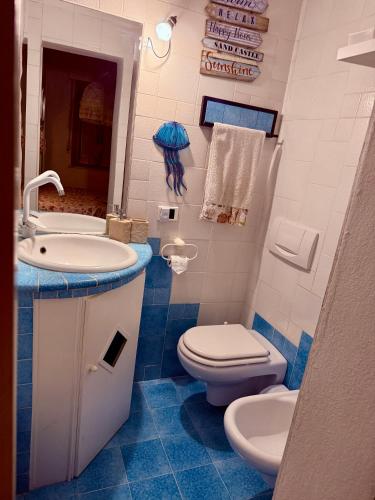 a blue and white bathroom with a toilet and a sink at Appartamento elba da Susanna in Portoferraio