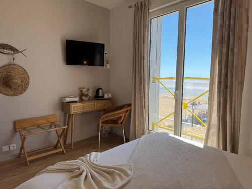 a bedroom with a bed and a window with a view at Acadie Saint Victor - Hôtel restaurant -Face mer- Châtelaillon plage in Châtelaillon-Plage