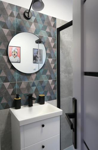 a bathroom with a white sink and a mirror at Las Tu Las Tam in Chudaczewko