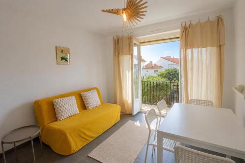 a living room with a yellow couch and a table at L'Albatros - Appartement de charme à Digoin in Digoin
