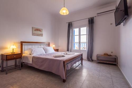 ein Schlafzimmer mit einem Bett und einem Fernseher in der Unterkunft Polyegos View in Pollonia