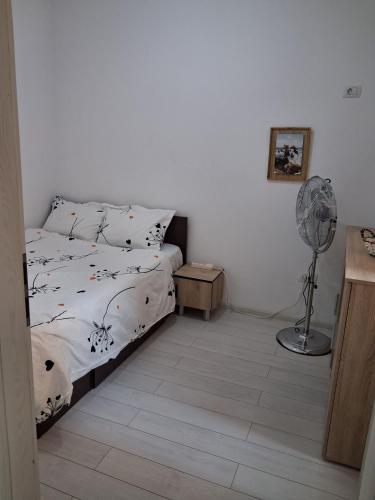 a small bedroom with a bed and a fan at Modern 1-Bedroom Apartment with AC, Free Parking & Self Check-in Bucharest-Militari in Dudu