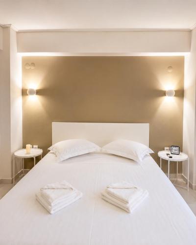 a white bed with two white towels on it at polyxeni house in Lygia