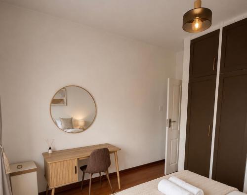 a bedroom with a bed and a mirror and a desk at The Oak in Strand