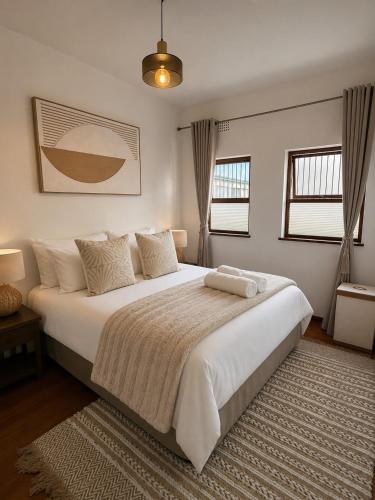 a bedroom with a large white bed with a rug at The Oak in Strand