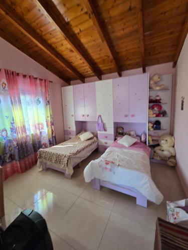 a bedroom with two beds in a room with wooden ceilings at Villa Theodora in Himare