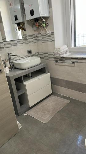 a bathroom with a sink and a counter with a mirror at Residence Parco Castello 1 in Novi Ligure