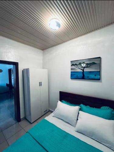 a bedroom with a bed and a door with a picture at PENTHOUSE MPINGA RIMWEe in Kigali