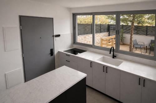 a kitchen with a counter and a sink and windows at סוויטת גן ליד הים in Qiryat Yam
