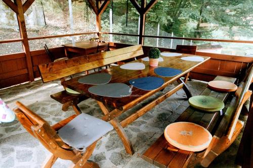 a wooden table and chairs in a room at Iezer Mountain Escape in Lunca Ampoiţei