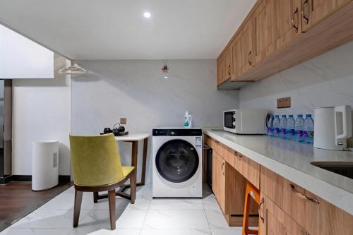 a kitchen with a washing machine and a yellow chair at SEEU Designer Apartment - Qiaoxiang Metro, Futian Shenzhen in Shenzhen