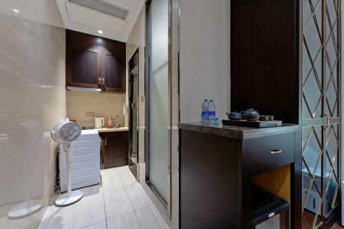a small kitchen with brown cabinets and a counter at SEEU Designer Apartment - Qiaoxiang Metro, Futian Shenzhen in Shenzhen