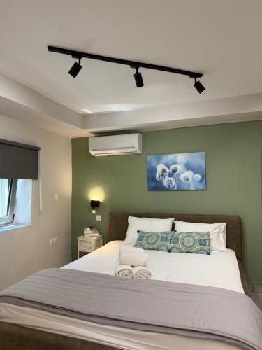 a bedroom with a large white bed with green walls at five pathways in Gargaliánoi