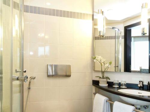 a bathroom with a shower and a sink and a mirror at ibis Kuwait Salmiya in Kuwait