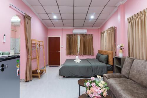 a pink room with a bed and a couch at PoonsukPlace Sampran in Ban Bang Yai Chuai