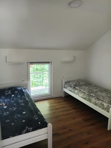 two beds in a room with a window at Villa Balic Sarajevo in Sarajevo