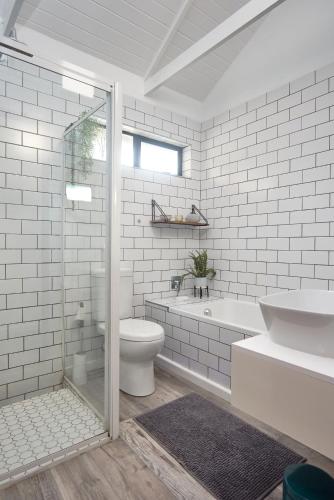 a bathroom with a toilet and a tub and a sink at Kiekiebos in Wilderness