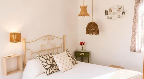 a bedroom with a bed with white sheets and pillows at La Pizpireta in Cazorla