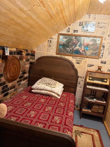 a bed in a room with a brick wall at Loukis dvars in Luokė