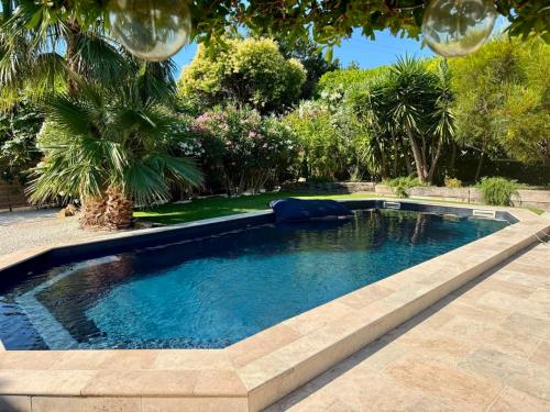 a swimming pool in a yard with trees at L'arbousier in Cassis