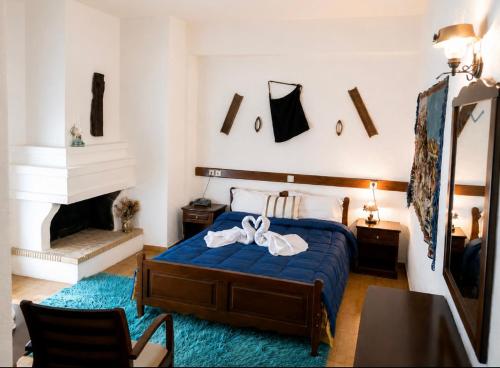 a bedroom with a blue bed and a fireplace at Sintrivanis Mountain in Áno Skotína