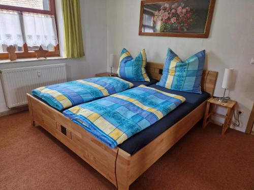 a bedroom with a bed with blue and yellow pillows at Ferienwohnung am Chemnitztalradweg in Taura