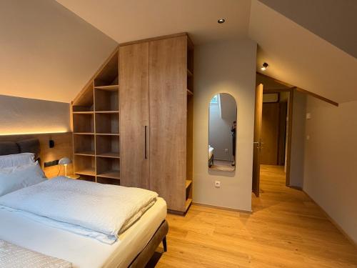 a bedroom with a bed and a large wooden cabinet at Riolina Suite in Mühlbach