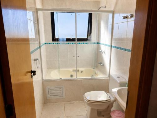 a bathroom with a tub and a toilet and a sink at Flat Serra negra prox ao Centro lazer completo in Serra Negra