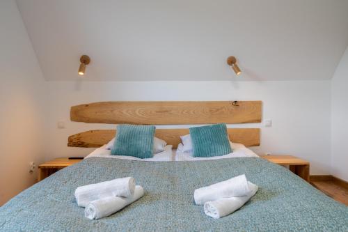 a bedroom with a bed with two towels on it at Czarna Owca in Biały Dunajec