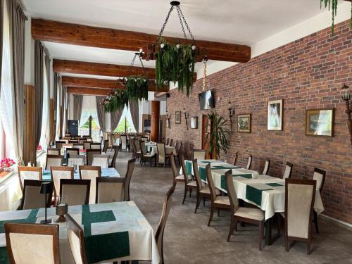 a restaurant with tables and chairs and a brick wall at Rotonde View in Predeal