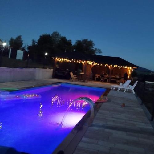 a swimming pool lit up at night with purple lights at Lipove Spa in Lipowe