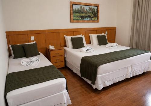 two beds in a hotel room next to each other at Flat Serra negra prox ao Centro lazer completo in Serra Negra