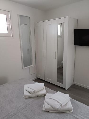 a white room with two towels on the floor and a mirror at Gianola Residence Monolocali Formia in Formia