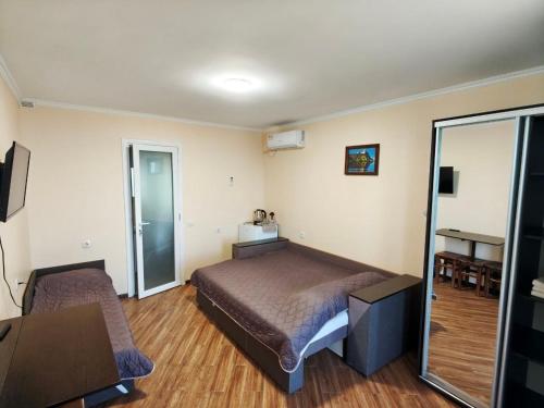 a bedroom with a bed and a mirror at Гостинний дім "Алмаз" in Kurortne