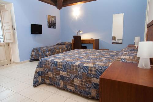 a bedroom with two beds and a tv on the wall at Feudo Vagliasindi -Wine Experience- in Randazzo