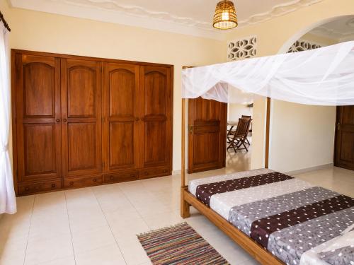 a bedroom with two beds and wooden cabinets at Appartement Baie-Rose SP Nosy-Be in Nosy Be