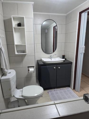 a bathroom with a toilet and a sink and a mirror at Unit 9 The Beachfront in Ramsgate