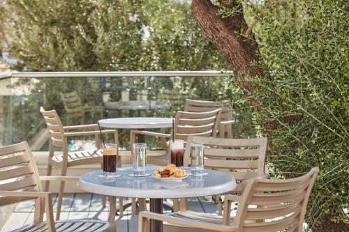two tables with drinks and a plate of food on a patio at Civitel Esprit in Athens