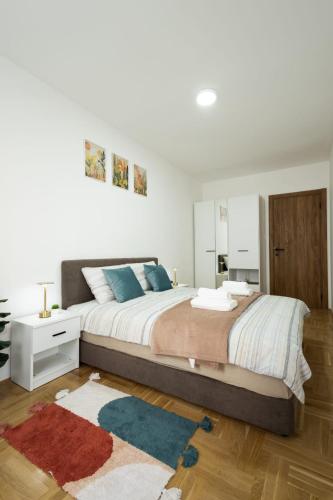 a white bedroom with a large bed and a mirror at Dana in Požarevac