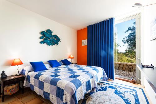 タヴィラにあるCasa da Sinaのベッドルーム(青と白のベッド1台、窓付)