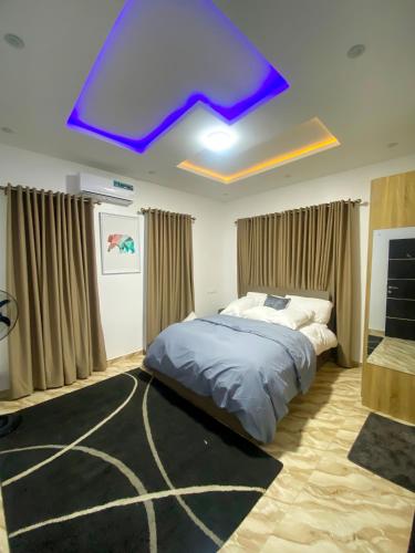 a bedroom with a bed and a purple ceiling at Heritage Apartment in Ibadan