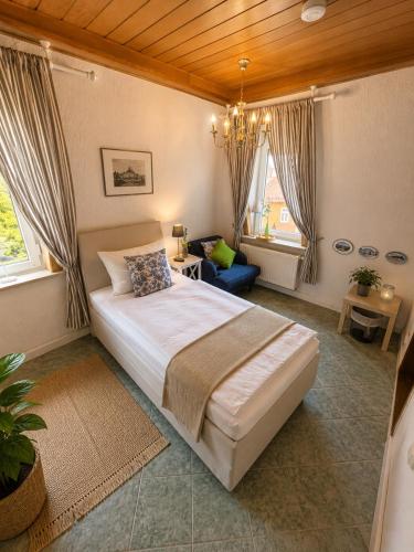 a bedroom with a large bed and a chandelier at Pension & Restaurant Zu den Linden Radebeul in Radebeul