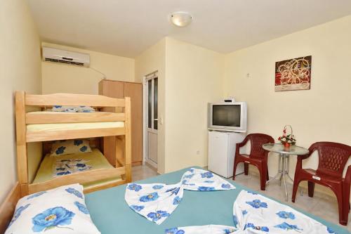 a bedroom with a bed and a small table with chairs at Vila Mia in Donji Štoj