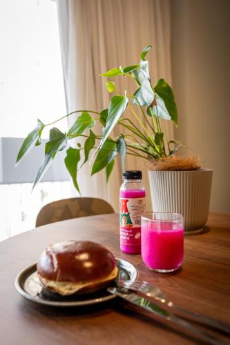 a donut and a glass of pink drink on a table at Studio Piedade 45 | More do seu jeito in Belém