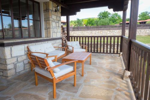 a patio with chairs and a table on a porch at Complex Rayuvski Han in Rayuvtsi
